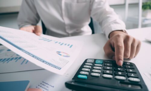 Business accounting concept, Business man using calculator with computer laptop, budget and loan paper in office.